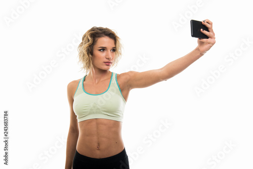 Portrait of beautiful young fit girl making selfie