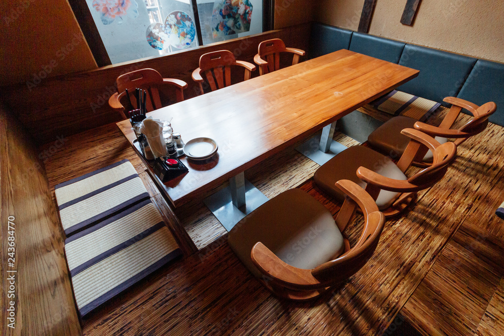 Japanese style ramen restaurant, Low table in center with seats on the ...