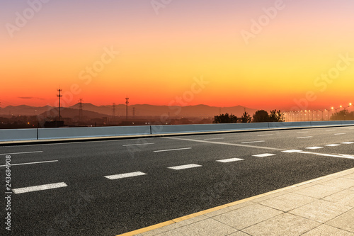 Asphalt road and hills at beautiful sunset