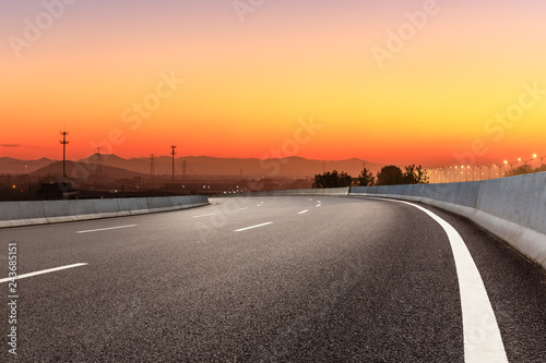 Asphalt road and hills at beautiful sunset