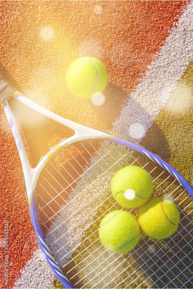 Tennis game. Tennis balls and racket on court background.