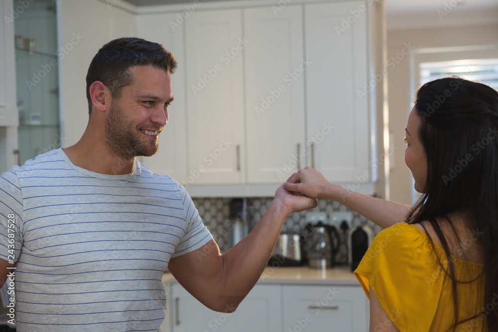 Obraz premium Couple dancing together in kitchen