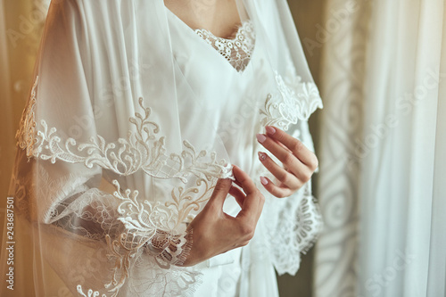 bride in a robe near the window,woman getting ready before wedding ceremony