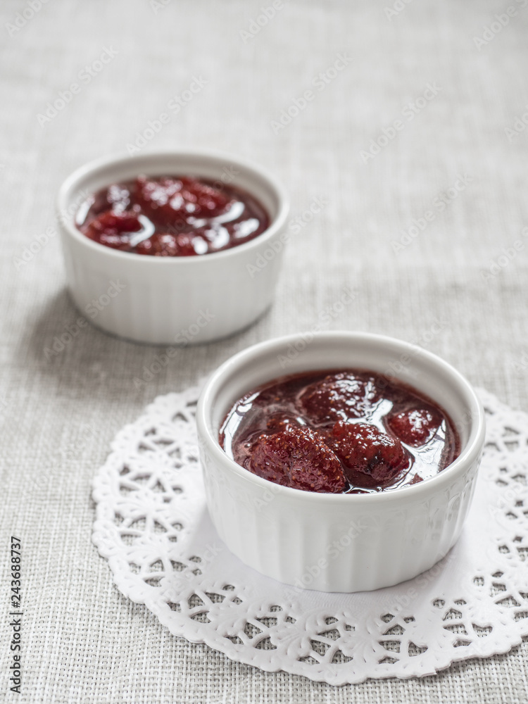 Homemade strawberry sweet delicious jam with whole berries on white background