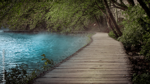 Empty and Lonely Path next to foggy and misty Water within the Plitvice Lakes National Park in Croatia at dawn