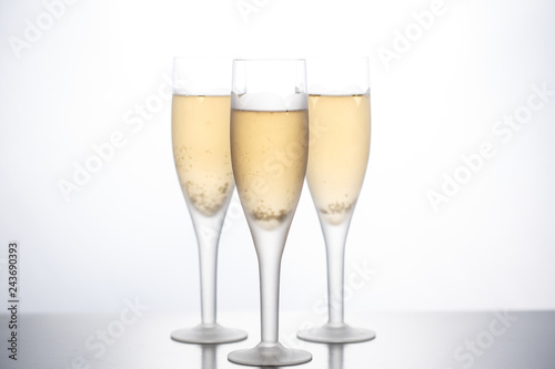 Glasses with champagne empty and filled on a white background.