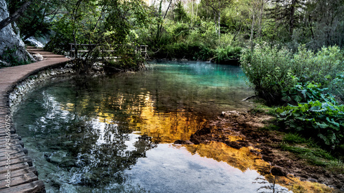 Empty and Lonely Path next to turquoise Water within the Plitvice Lakes National Park in Croatia