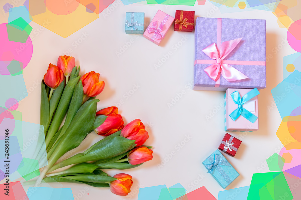 Tulip flowers and colorful gift boxes on pastel background. Top view with copy space.