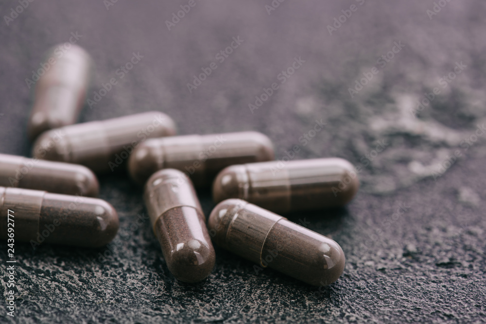 selective focus of pills on grey surface with copy space on grey background