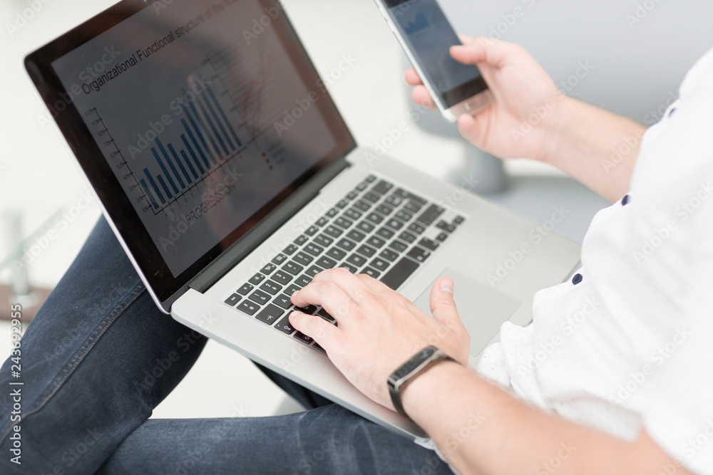 close up. businessman using smartphone and laptop