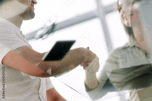 bottom view.businessman and businesswoman shaking hands over the Desk