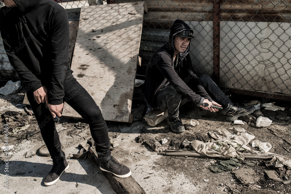 Criminals in hoodies reloading guns and getting ready to attack Criminals in hoodies reloading guns and getting ready to attack