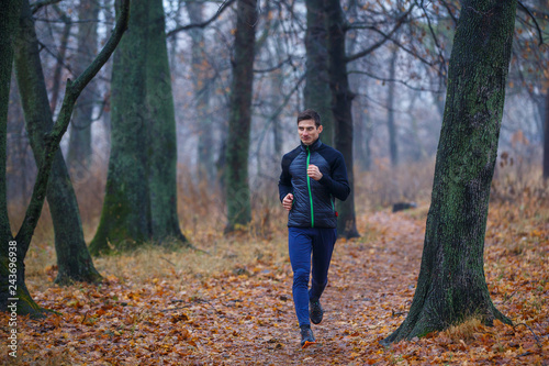 Young man jogging in autumn park in the morning © skumer