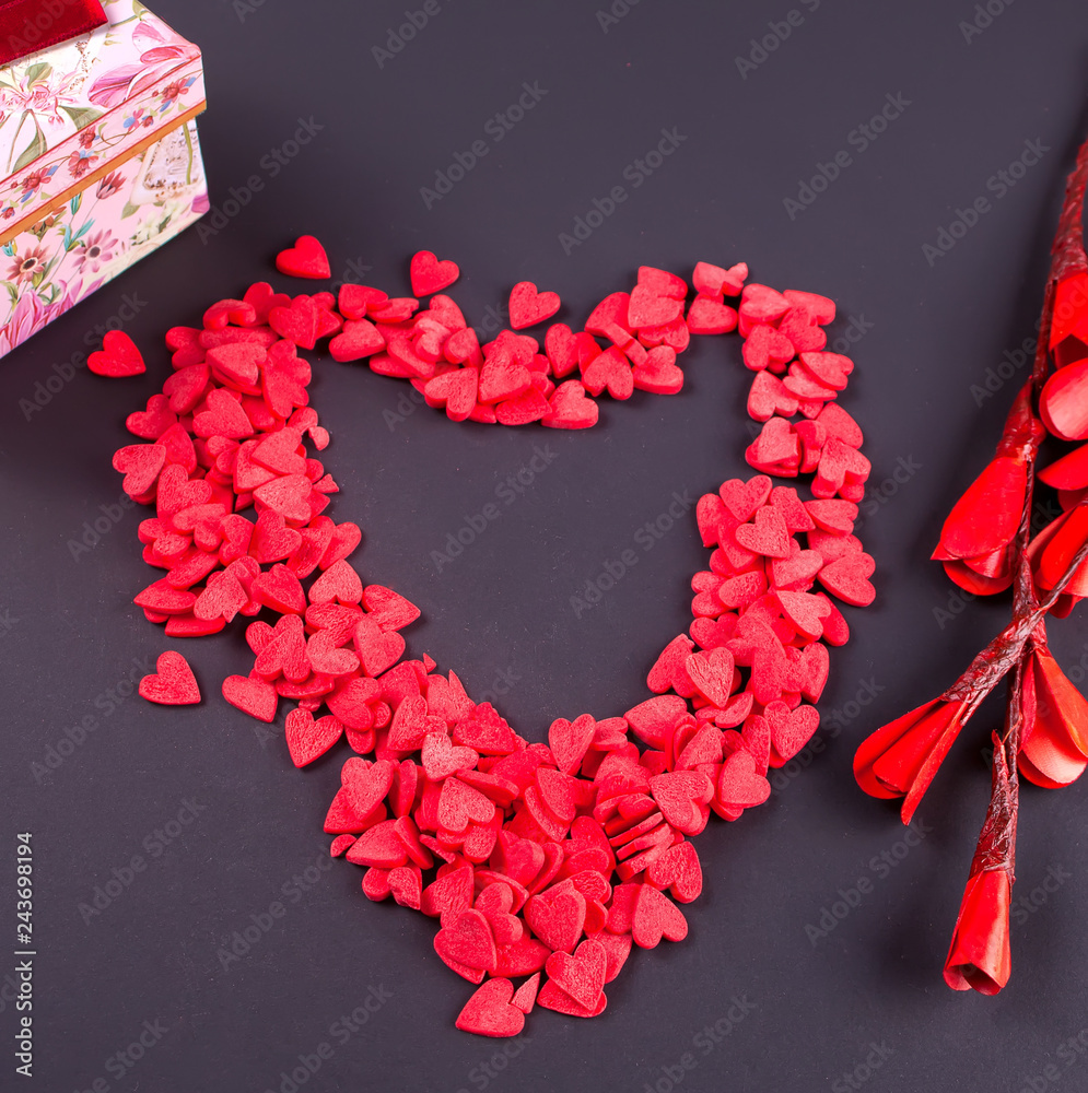 Obraz premium Symbol heart of candy sweets on black background. Top view.