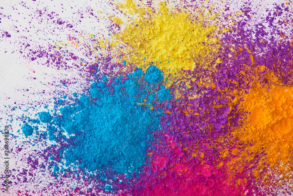 Top View Of Explotion Of Yellow Purple Orange And Blue Holi Powder On top-view-of-explotion-of-yellow-purple-orange-and-blue-holi-powder-on