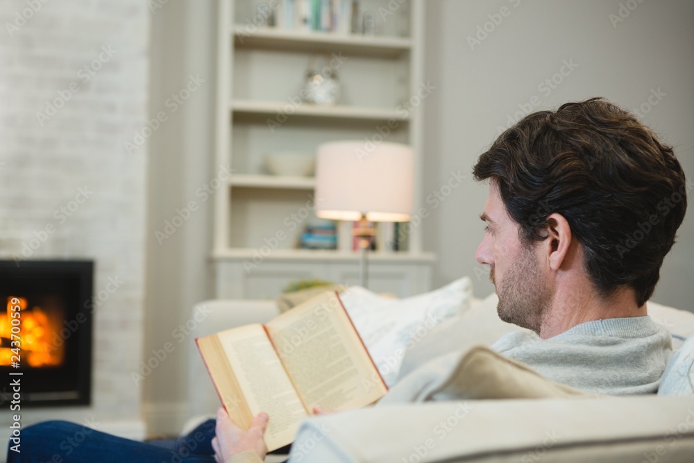 Obraz premium Man reading a book in living room