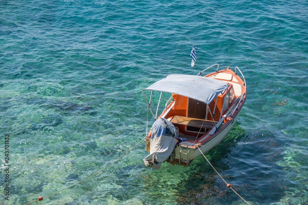 Obraz premium Small white brown wooden motorized boat anchored on the shore