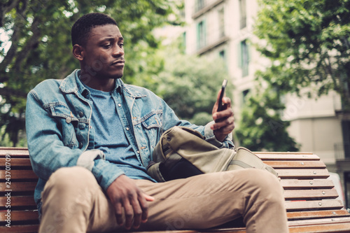 Young african-american with mobile phone outdoors