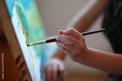 Fototapeta Naklejka Na Ścianę i Meble -  Preschool girl painting in art class. Close up photo brush in hand