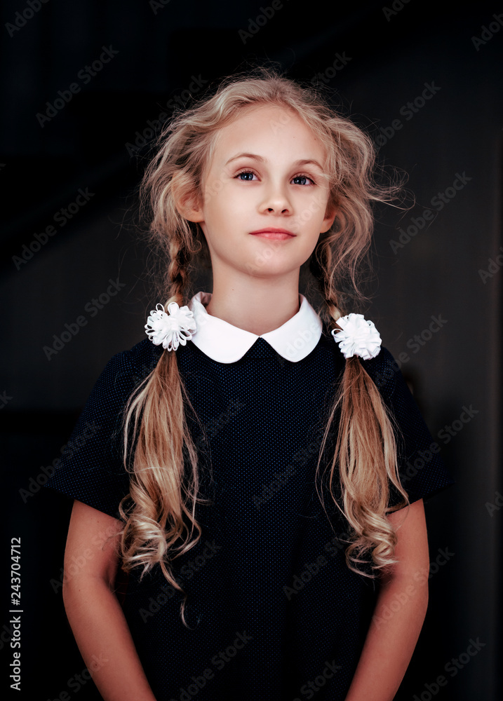 Portrait of a smiling blonde seven year old girl in school uniform foto de  Stock | Adobe Stock