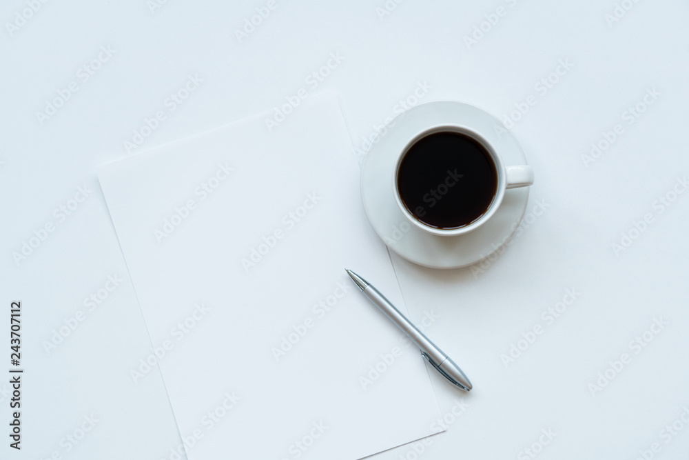 Cup of coffee, piece of paper and pen on the table. Top view Cup of coffee, piece of paper and pen on the table. Top view