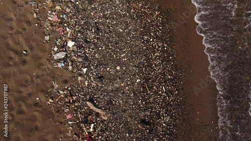Aerial shot of beach covered in plastic pollution photo