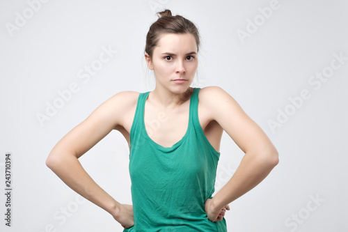 Woman, holding hands on hips, looking with angry expression, being offended