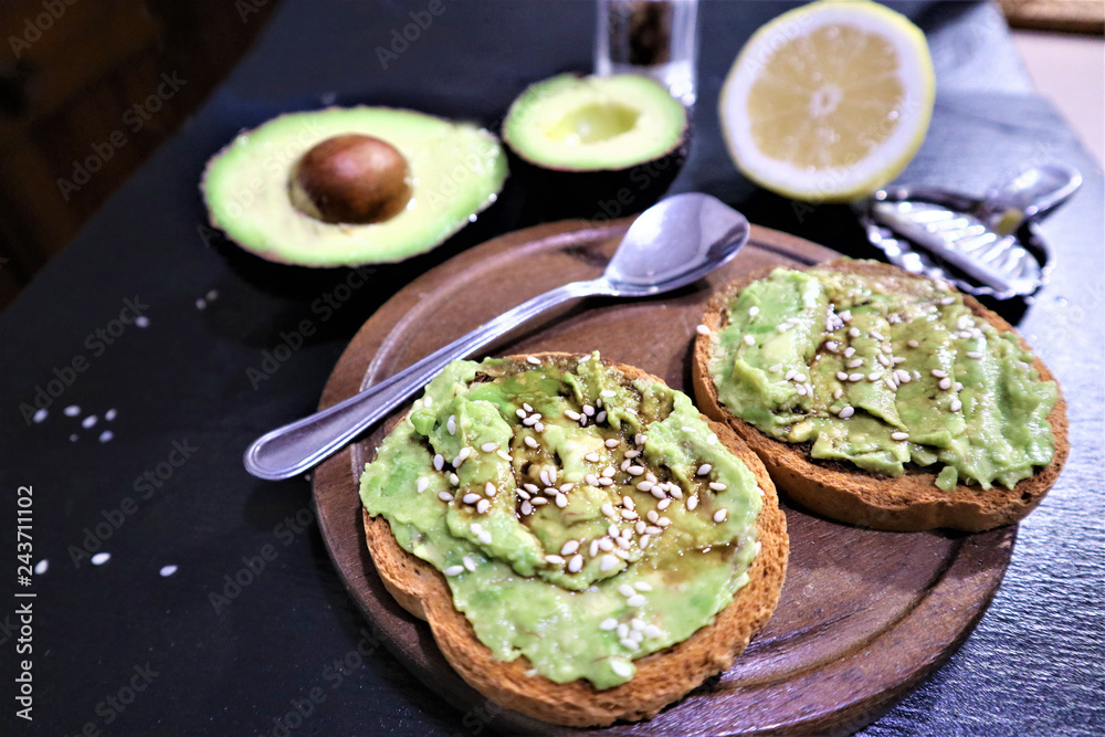Avocado toast , overhead viewy avocado sandwich on toast bread made with fresh avocado paste on the black background Avocado toast , overhead viewy avocado sandwich on toast bread made with fresh avocado paste on the black background