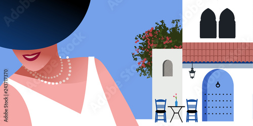 Woman with blue hat and pearls necklace, on background of typical morocco style mediterranean village. Blue door under a roof, Moorish windows, chairs and a small table with vase. Bougainvillea