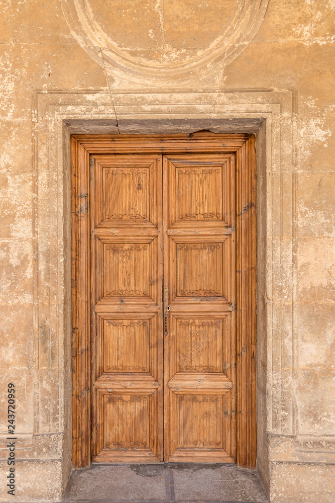 Classic solid wood door in one of the buildings of the Alhambra, Granada