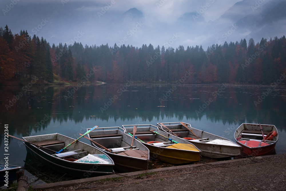Five colorful boats on evening in lake Laghi di Fusine