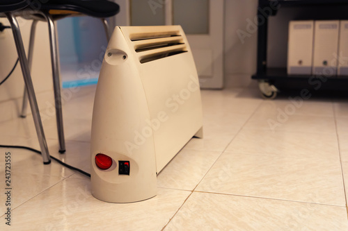 Portable heater in small office. Heating device.