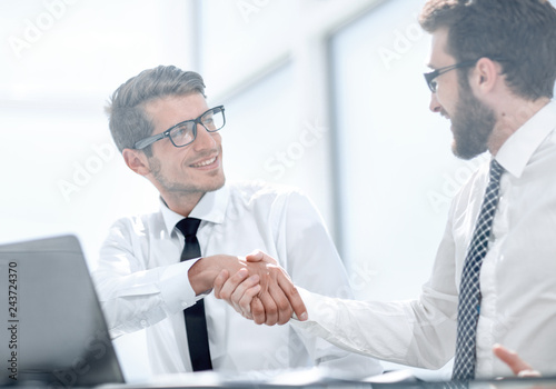handshake business colleagues sitting at their Desk