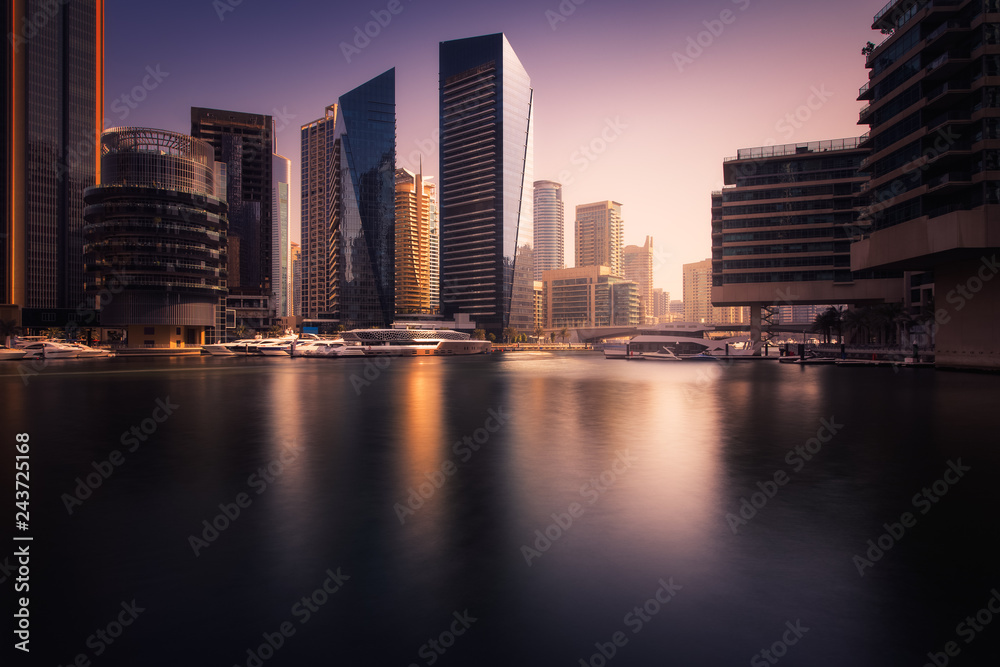 Fototapeta premium Beautiful view to Dubai Marina Promenade, UAE. Long exposure time lapse effect at sunset