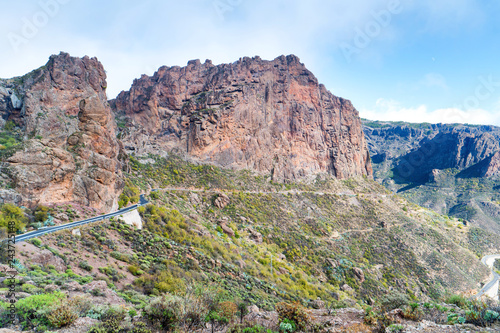 Nature landscape of Canary Island with mountain range, green hills and curvy road