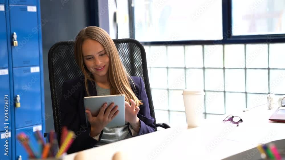 Young happy businesswoman working on tablet at her desk Young happy businesswoman working on tablet at her desk