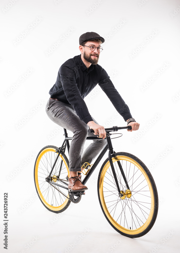 Portrait of a hipster beard man riding on bicycle over gray background Portrait of a hipster beard man riding on bicycle over gray background