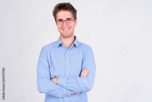 Young happy businessman with eyeglasses smiling and crossing arms © Ranta Images