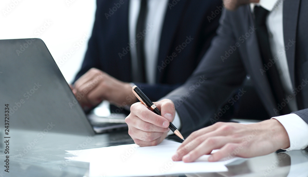 Hand of businesswoman writing on paper in office Hand of businesswoman writing on paper in office