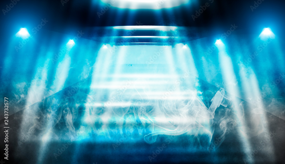 Background of empty dark room with rays of light. Concrete floor with light reflection. Smoke, neon blue light Background of empty dark room with rays of light. Concrete floor with light reflection. Smoke, neon blue light