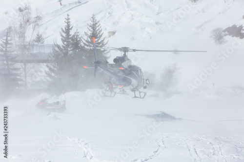 Rescue helicopter during a snow storm in the mountains