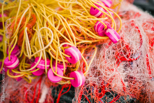 Colorful fishing nets with bright pink floats and vibrant threads. Close-up of traditional fishing gear on a tropical island, perfect for travel, culture and marine industry themes
