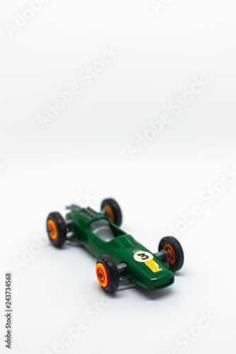 Miniature green race car with number 3 isolated on a white background, perfect for on a three-year-old birthday party cart