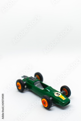 Miniature green race car with number 3 isolated on a white background, perfect for on a three-year-old birthday party cart