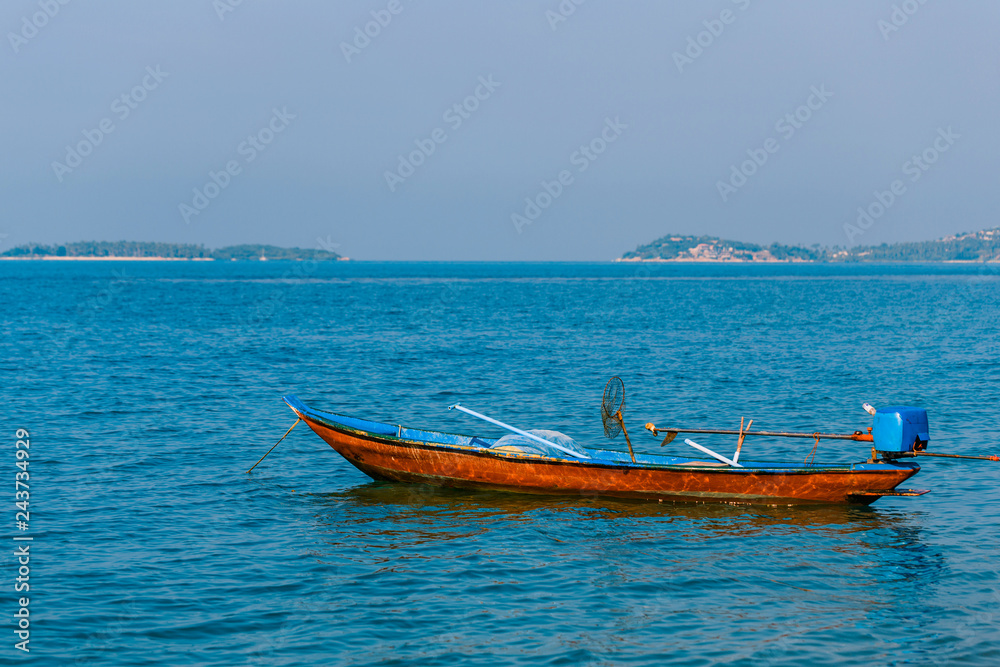 Thai fishing boat on the waves of the azure sea. Motor fishing boat on the background of the Islands