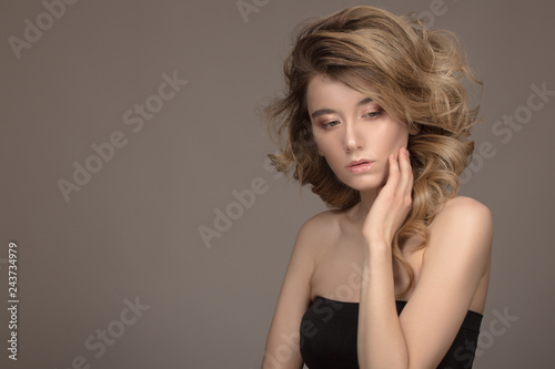 Fashion woman curly hair. Beautiful make-up. Dark background
