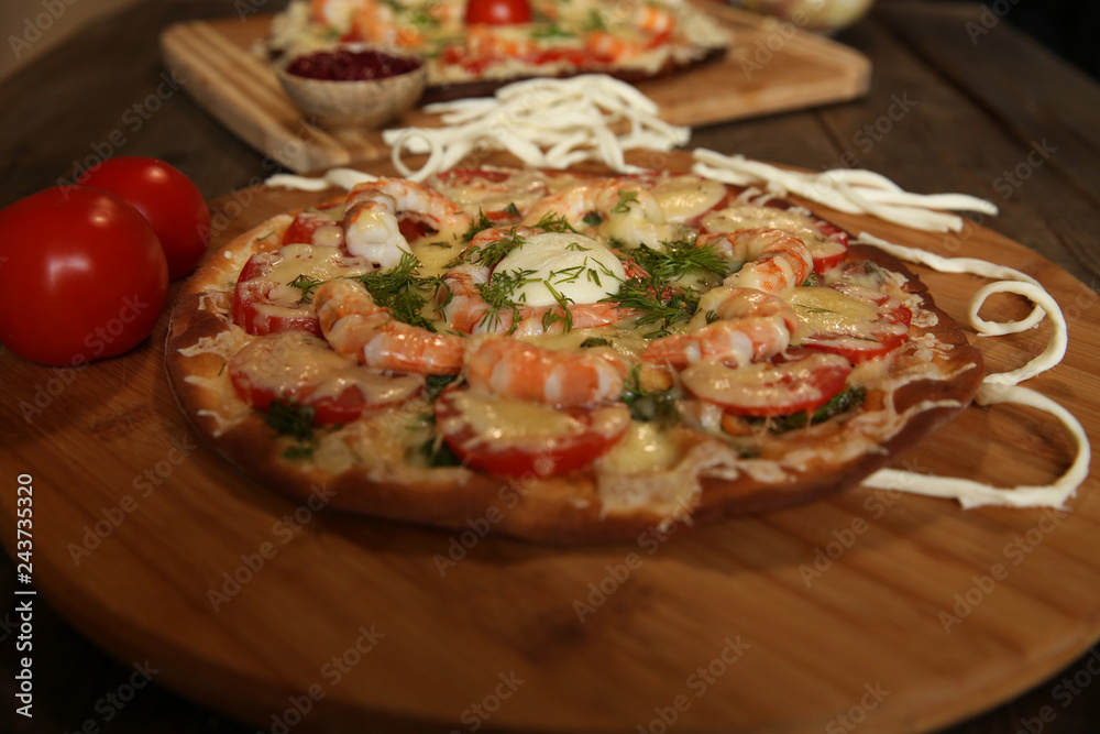seafood pizza, shrimp and mozzarella cheese on a wooden table close-up