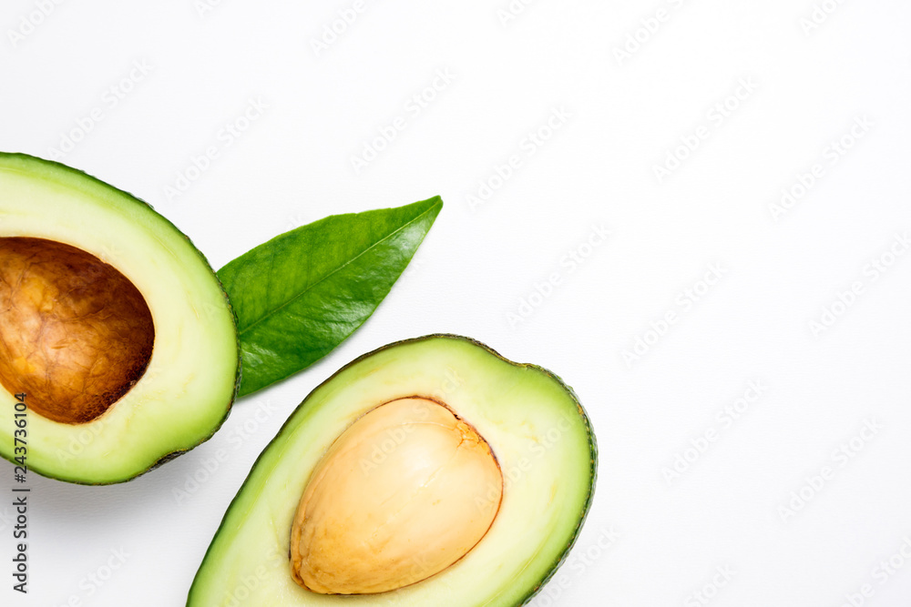 Avocado on white background. Tropical abstract background with avocado and leaf. Flat lay. Top view, copy space Avocado on white background. Tropical abstract background with avocado and leaf. Flat lay. Top view, copy space