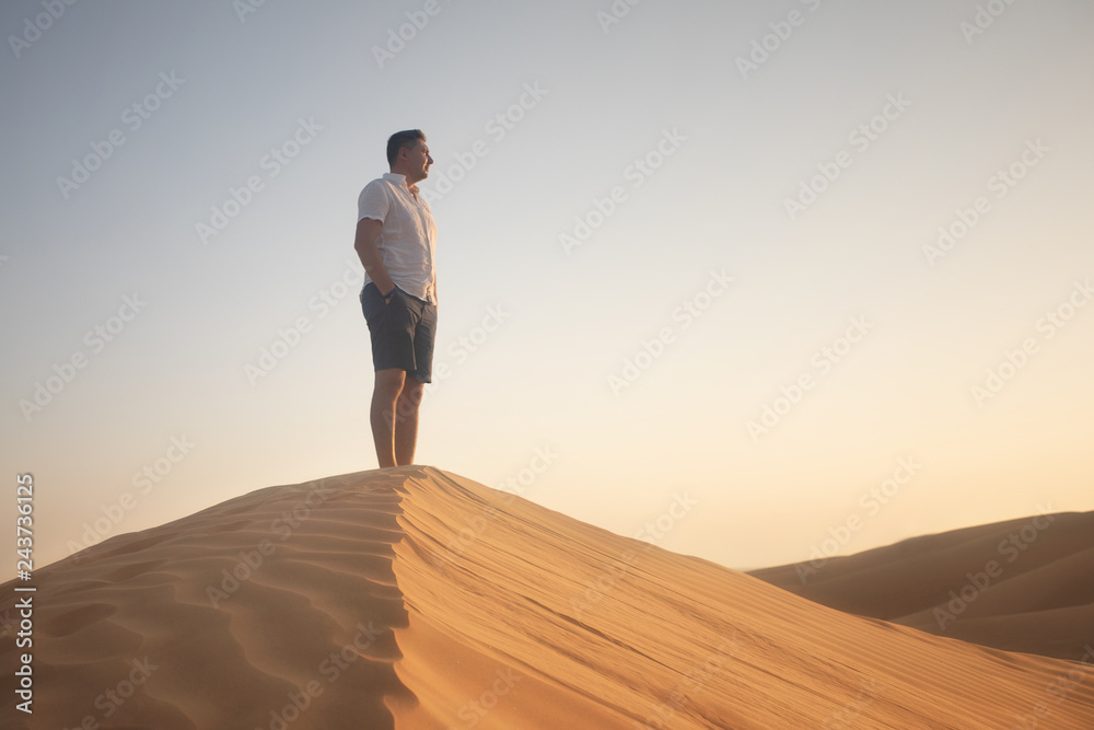 Fototapeta premium man standing on sand dune