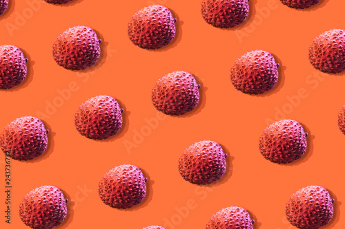 Lychee fruits colorful pattern on a orange background. Tropical fruits concept. Flat lay. Top view.